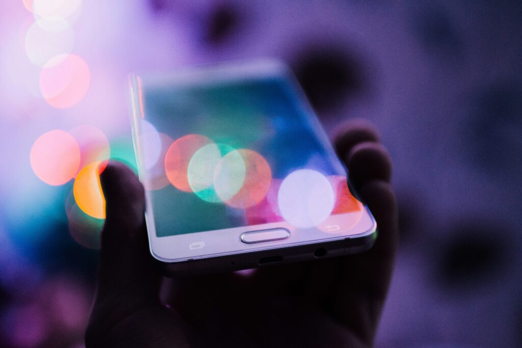 smartphone tenu à une main face à une source de lumière vive