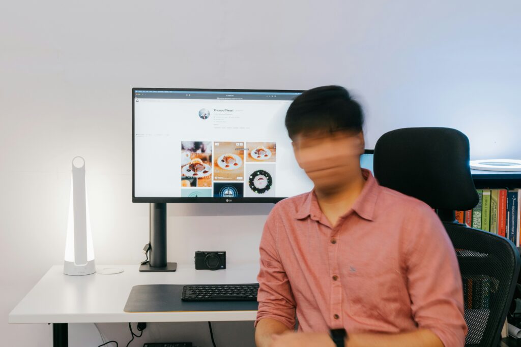 visage flouté d'un homme sur son ordinateur